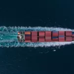 Aerial view of cargo container ship in the sea at night